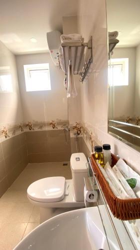 a white bathroom with a toilet and a sink at Lộc Phú Villa - Hoanglee in Da Lat