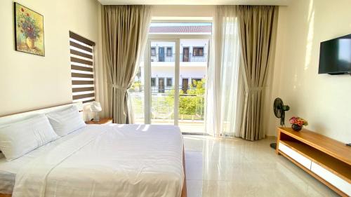 a bedroom with a white bed and a large window at Lộc Phú Villa - Hoanglee in Da Lat