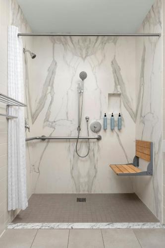 a bathroom with a shower with a marble wall at Courtyard by Marriott Fishermans Wharf in San Francisco