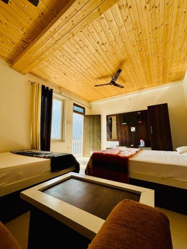 a room with three beds and a ceiling at The HIGHLIGHT STAY in Uttarkāshi