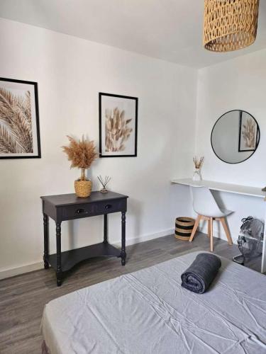a bedroom with a desk and a bed and a table at Mas des Palmiers in Grignan