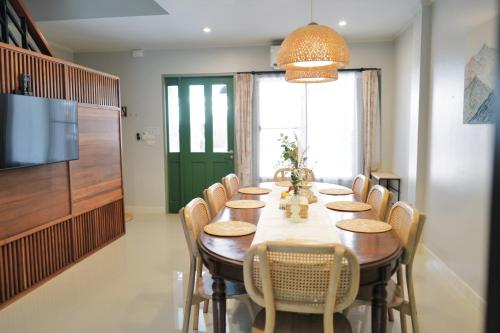 a dining room with a long table and chairs at My happy place in CNX in Chiang Mai