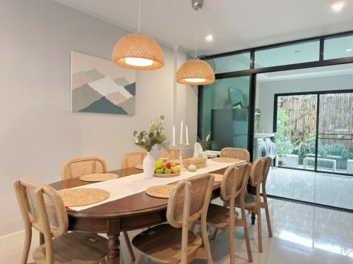 a dining room with a wooden table and chairs at My happy place in CNX in Chiang Mai