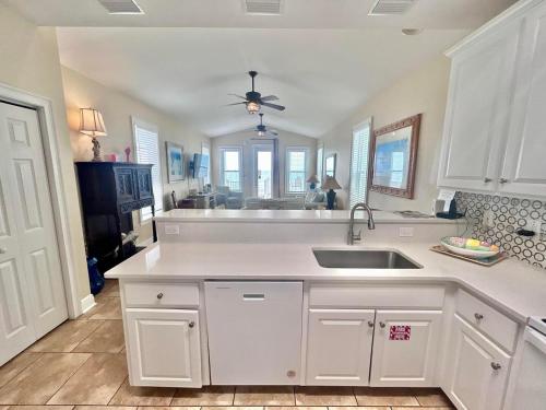 a kitchen with white cabinets and a sink at Skinny Mini-Beachfront-3BR in St. George Island
