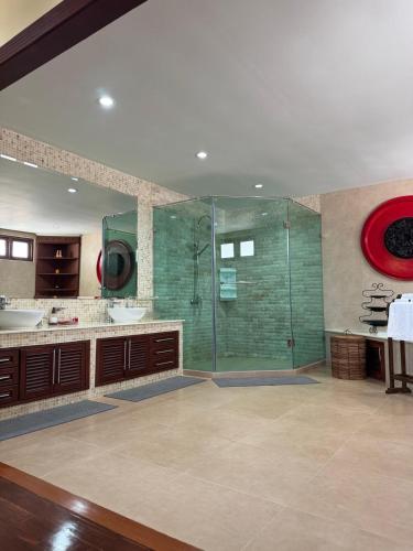 a bathroom with a glass shower and a sink at Baan Katthaliya in Hua Hin