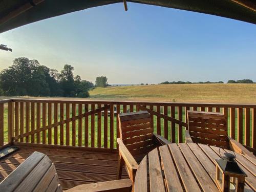 two chairs and a wooden table on a deck at Pheasant Lodge in Pangbourne