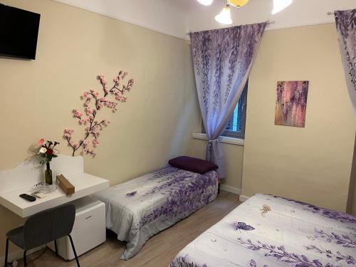 a bedroom with two beds and a desk and a window at Agapanthus in Offida