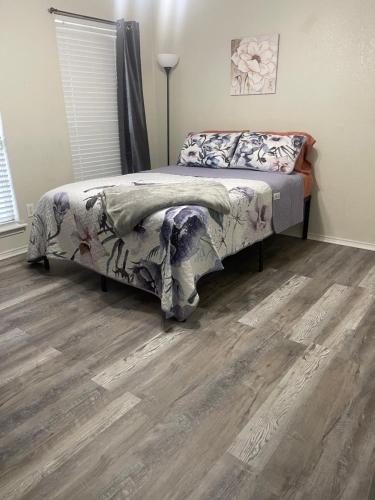 a bedroom with a bed and a wooden floor at Kindness Dwells in Killeen