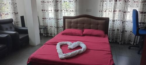 a bed with a heart shaped pillow on it at Rohan's Residence in Kandana