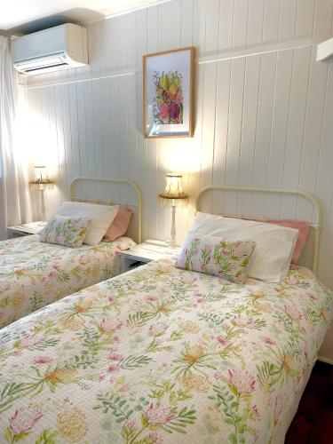 a bedroom with two beds and two tables with lamps at Noosa Hinterland Escape in Black Mountain