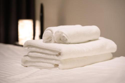 a stack of white towels stacked on a bed at Mondomio 207 in Sapporo