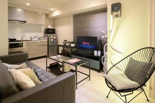 a living room with a couch and a tv at Mondomio 207 in Sapporo