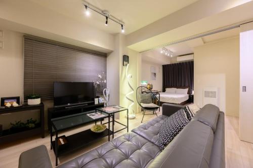 a living room with a couch and a television at Mondomio 207 in Sapporo