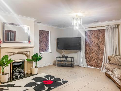 a living room with a fireplace and a flat screen tv at Gokula House in Cockermouth