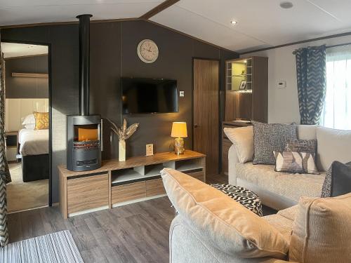 a living room with a couch and a tv at Herdwick Lodge - Uk51383 in Westward