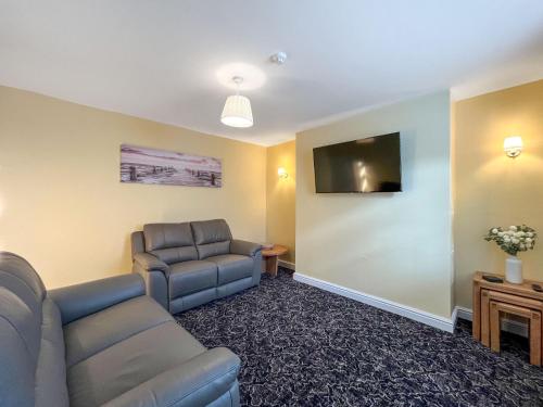 a living room with a couch and a flat screen tv at Albert Cottage in Llandudno