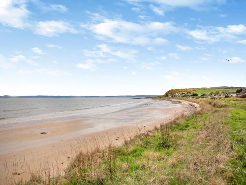a sandy beach with a view of the ocean at Wee Shore Walk in Balintore