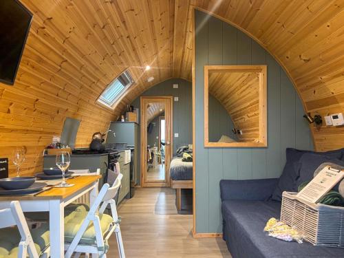 a living room with a blue couch and a kitchen at Curlew - Uk51340 in Draughton