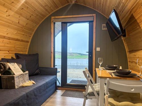 a living room with a couch and a table with a television at Curlew - Uk51340 in Draughton