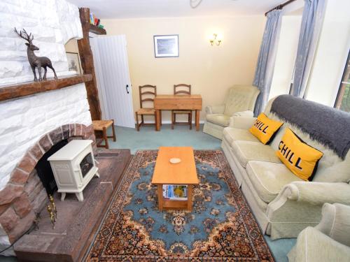 a living room with a couch and a fireplace at The Barley Mow in Kirkoswald