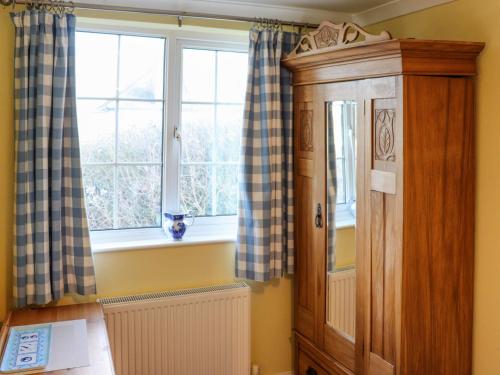 a room with a window and a wooden cabinet at The Cottage in Broad Haven