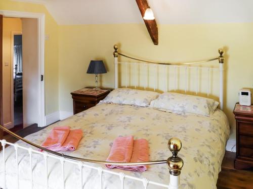 a bedroom with a bed with two pillows on it at The Cottage in Broad Haven