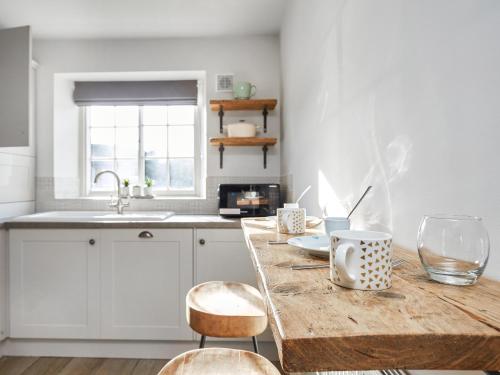 a kitchen with a wooden table with chairs and a sink at Hayy Bondgate Cottage in Harewood