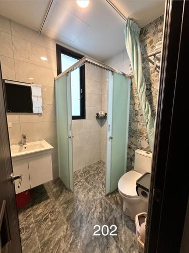 a bathroom with a toilet and a sink at Fu Qiaoqing Travel電梯獨棟 in Wujie
