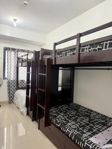 two bunk beds in a room with a bed at Blanc Suite in Dasmariñas