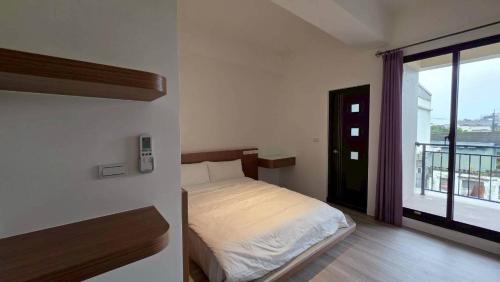 a bedroom with a bed and a large window at Fu Qiaoqing Travel電梯獨棟 in Wujie