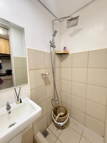 a bathroom with a sink and a shower with a toilet at Blanc Suite in Dasmariñas