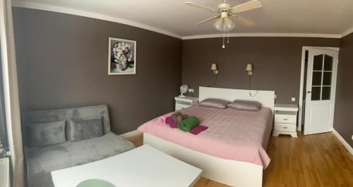 a bedroom with a large bed and a fan at Kovarnu street apartment in Cēsis