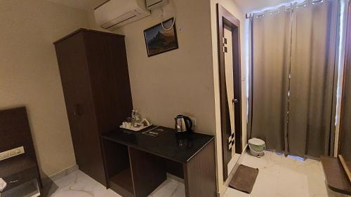 a bathroom with a shower and a table with a phone at Sky Loft near Kempegowda International Airport in Muthugadahalli