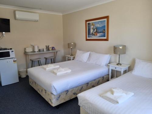 a hotel room with two beds and a kitchen at Ongerup Hotel in Ongerup