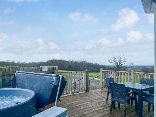 a deck with a hot tub and a table and chairs at Oak Tree Lodge - Uk51429 in Westward