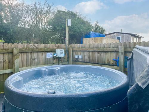 a large tub of water in front of a wooden fence at Oak Tree Lodge - Uk51429 in Westward