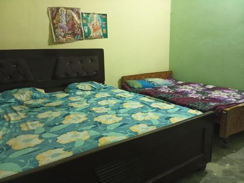 a bedroom with two beds in a room with flowers at ram sadan in Ayodhya