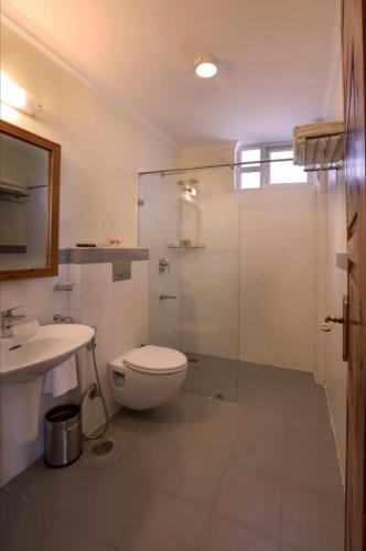 a bathroom with a toilet and a glass shower at Sumer Hotel in Sarahan