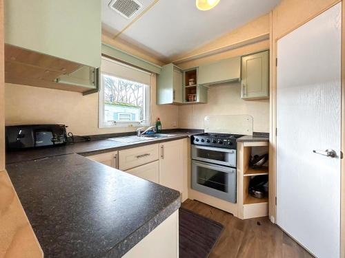 a kitchen with a sink and a stove top oven at Wah Caravan in Dundee