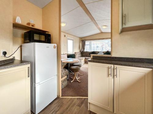 a kitchen with a refrigerator and a living room at Wah Caravan in Dundee