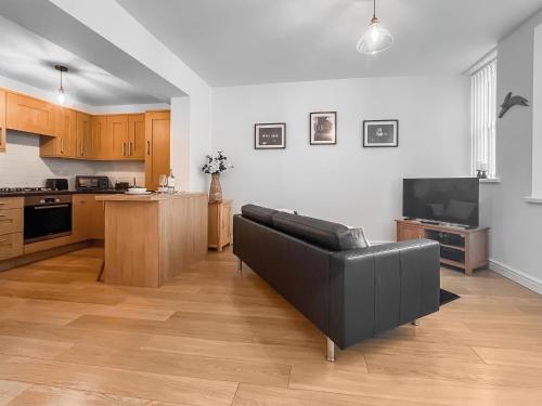 a living room with a couch and a kitchen at Old Steamship Quarters in Whitby