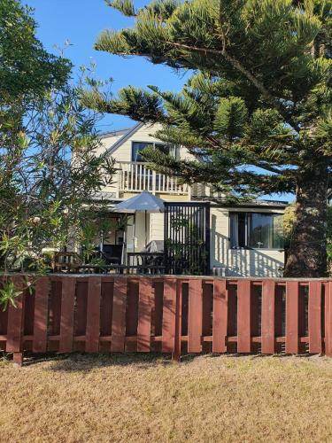 a wooden fence in front of a house at Estuary Hideaway in Whangamata