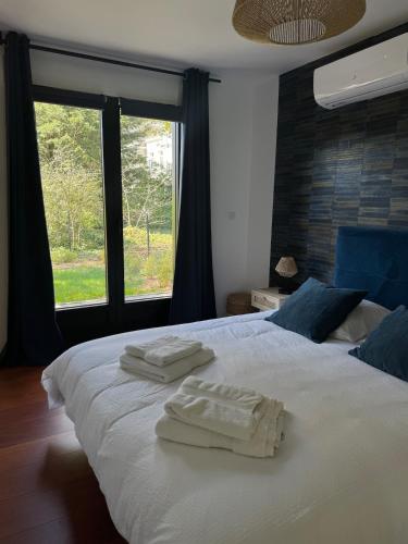 a bedroom with a white bed with towels on it at La Château de Toile, Gîte du Marronnier in Hersin-Coupigny