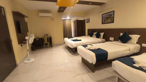a hotel room with two beds and a desk at Sky Loft near Kempegowda International Airport in Muthugadahalli