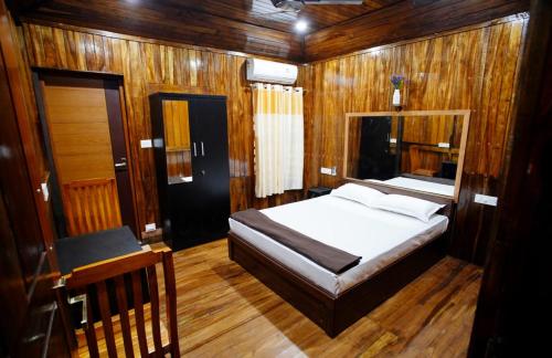 a bedroom with a bed and a desk in a boat at JackRoot Athirappilly in Kallana