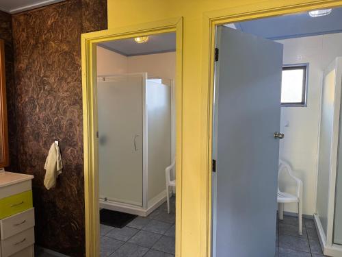 a bathroom with a yellow door in a room at Freestone off-grid cabin in Manapouri
