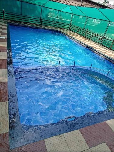 a large swimming pool with blue water at JackRoot Athirappilly in Kallana