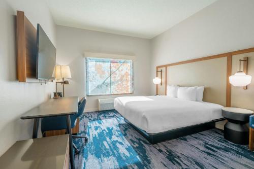 a hotel room with a bed and a desk at Fairfield Inn & Suites by Marriott Atlanta Kennesaw in Kennesaw