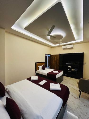 a bedroom with two beds and a ceiling at Hotel DVL INN- Near Jalmahal Jaipur in Jaipur