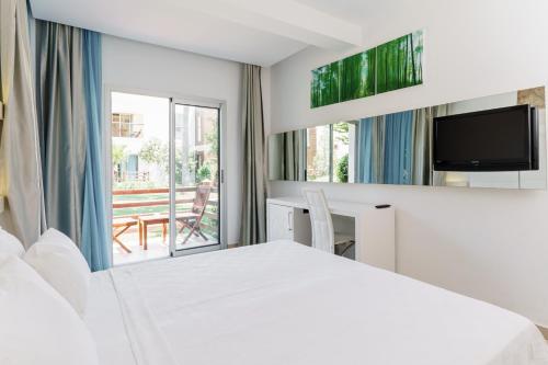 a bedroom with a white bed and a balcony at Costa Luvi Hotel Bodrum - All Inclusive in Gümbet